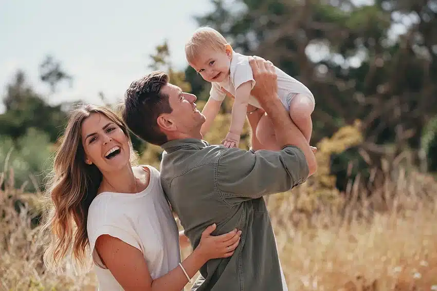 Famille jouant avec leur bébé en pleine nature, entre rires, tendresse et complicité – Photographie authentique et lumineuse.