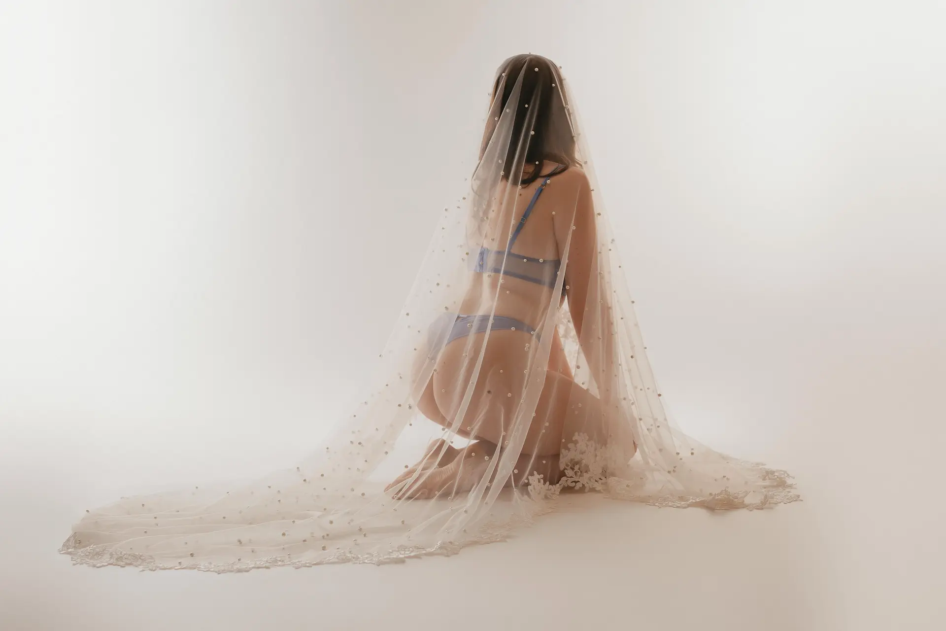 séance photo boudoir en studio d'une femme avec son voile de mariée