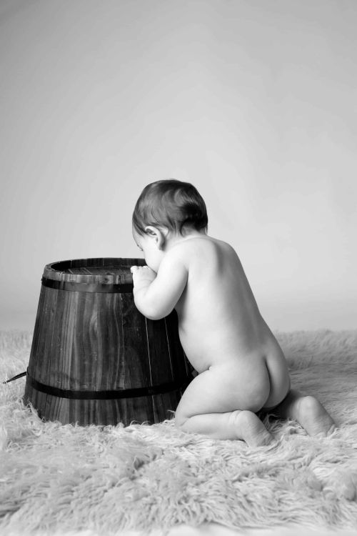 Photographie d'un bébé tout nu en studio.