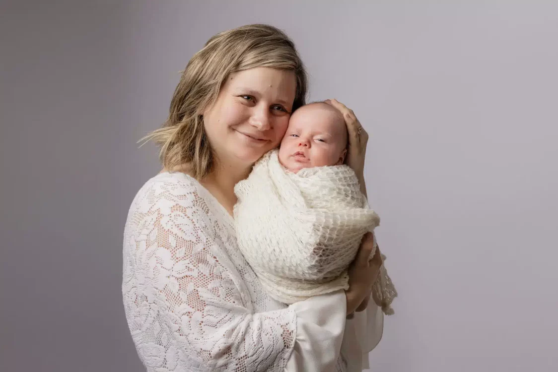 Portrait intime d'une maman et son nouveau-né, lumière douce de studio à Court-Saint-Étienne