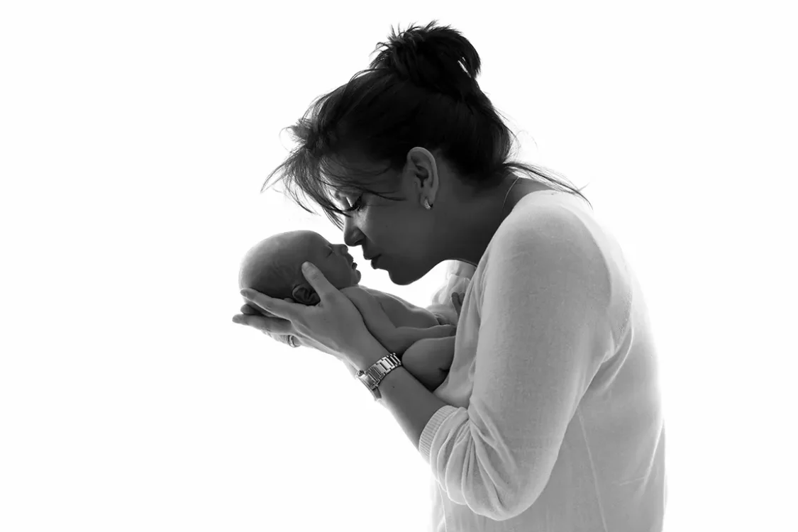 Portrait intime d'une maman et son nouveau-né, lumière douce de studio à Court-Saint-Étienne